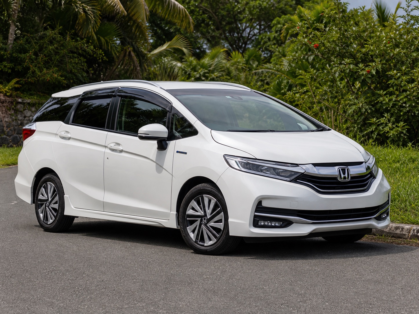 White 2021 Honda Shuttle parked on a Jamaica road with tropical greenery